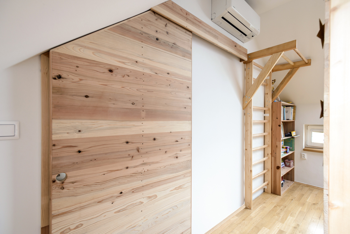 Interiér podkrovního bytu ze dřeva GENKI, posuvné dveře barndoor